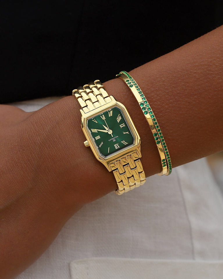 A square womens watch in 22k gold from Waldor & Co. with green Diamond Cut Sapphire Crystal glass dial. Seiko movement. The model is Eternal 22 Bellagio.