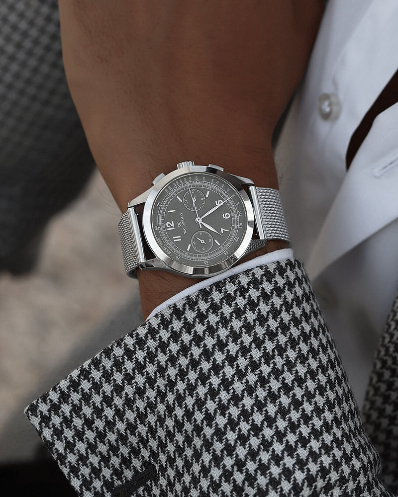 A round mens watch in rhodium-plated silver from Waldor & Co. with grey dial in brass. Seiko movement. The model is Chrono 39 Cinque Terre. 39mm