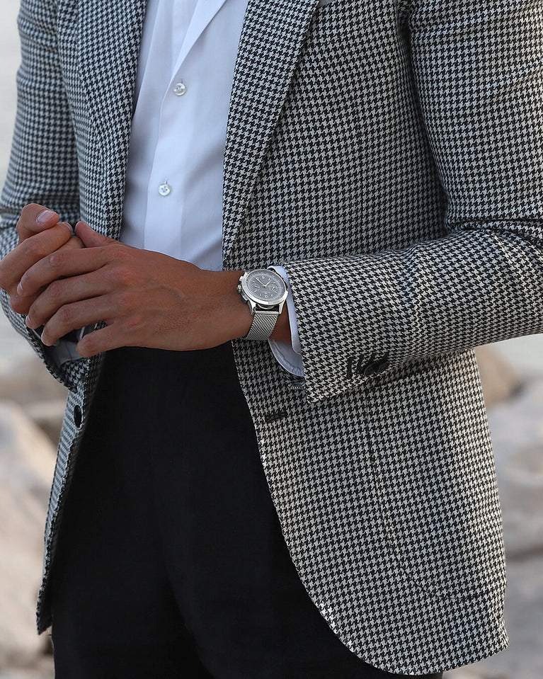 En rund herrklocka i rodiumpläterat silver från WALDOR & CO. med svart urtavla i brass. Seiko urverk. Modellen är Chrono 39 Cinque Terre. 39mm