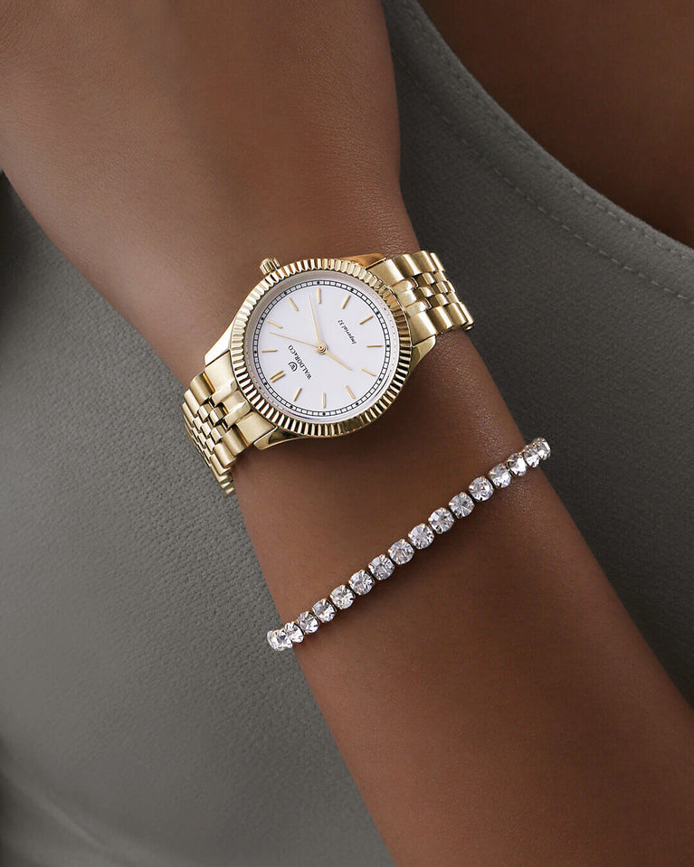 A round womens watch in 14k gold from Waldor & Co. with white sunray dial and a second hand. Seiko movement. The model is Imperial 32 Positano 32mm.