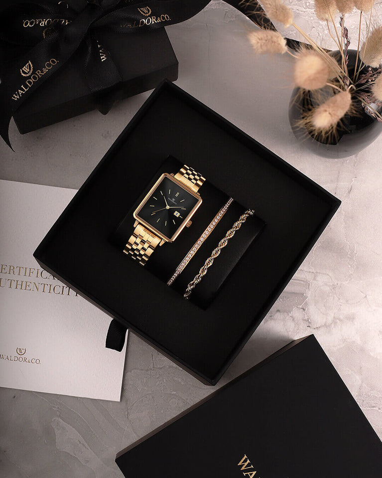 A square womens watch in 14k gold from Waldor & Co. with black sunray dial and a second hand. Seiko movement. The model is Delight 32 Chelsea 28x32mm.