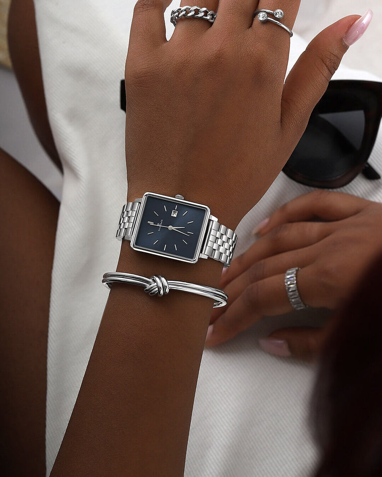 A square womens watch in silver from WALDOR & CO. with blue sunray dial and a second hand. The model is Delight 32 Chelsea 28x32mm.
