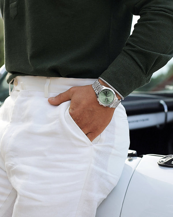 En rund herrklocka i rodiumpläterat silver från WALDOR & CO. med grön sunray urtavla och en sekundvisare. Seiko urverk. Modellen är Chrono 39 Porto Cervo.