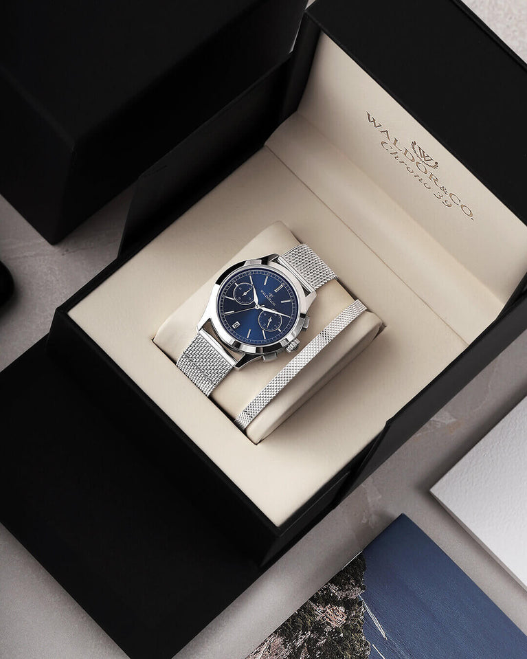  En rund herrklocka i rodiumpläterat silver från WALDOR & CO. med blå sunray urtavla och en sekundvisare. Seiko urverk. Modellen är Chrono 39 Sardinia 39mm.