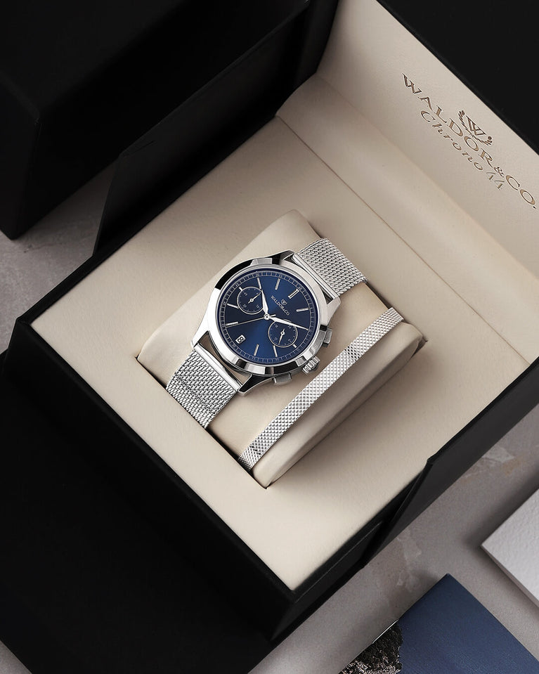  En rund herrklocka i rodiumpläterat silver från WALDOR & CO. med blå sunray urtavla och en sekundvisare. Seiko urverk. Modellen är Chrono 44 Sardinia 44mm.