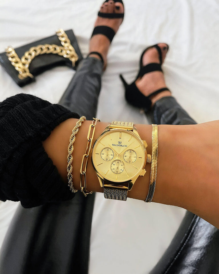 A round womens watch in 14k gold-plated 316L stainless steel from Waldor & Co. with gold dial and a second hand. Seiko movement. The model is Epoch 36 Formentera 36mm.